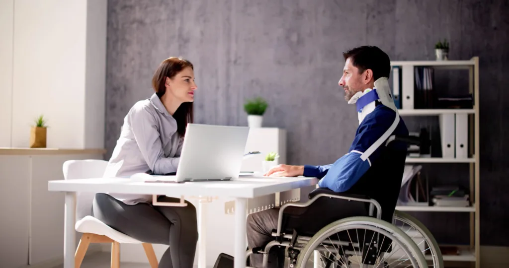Injured person sitting in wheelchair and lawyer