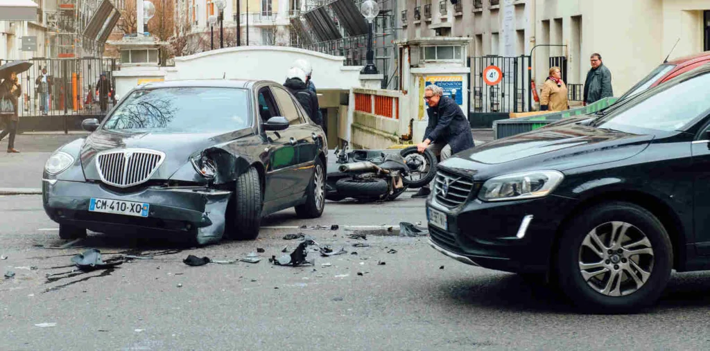Scene of a car and motorcycle accident with damaged vehicles and debris on road, highlighting a drugged driving accident case legal assistance.