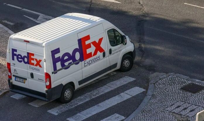 FedEx delivery truck on a city street, relevant to Houston delivery truck accident lawyers.