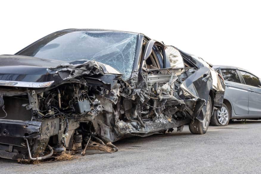 Severely damaged car from a crash in Houston, illustrating the impact of urban sprawl and long commutes on car crash fatalities.
