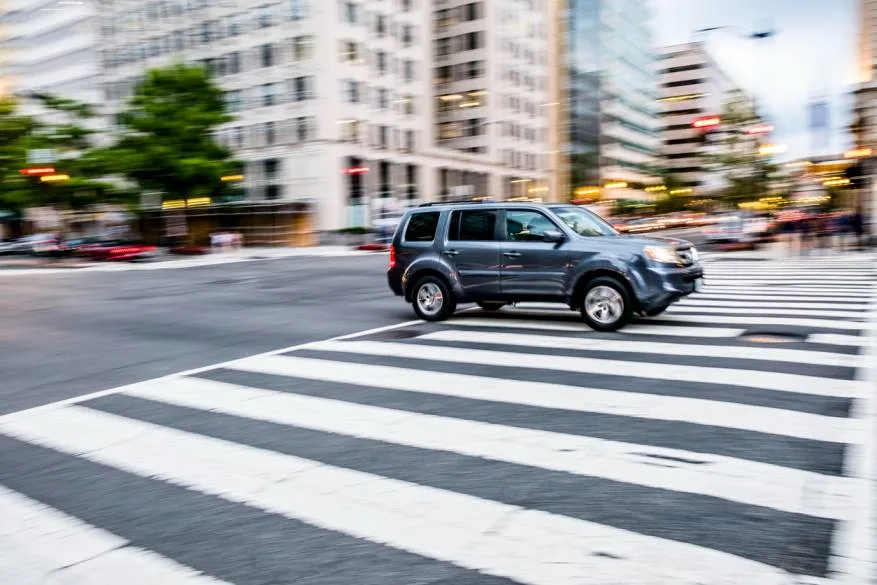 SUV speeding through a crosswalk in Houston, illustrating the rising threat of SUV-related pedestrian fatalities in urban areas.